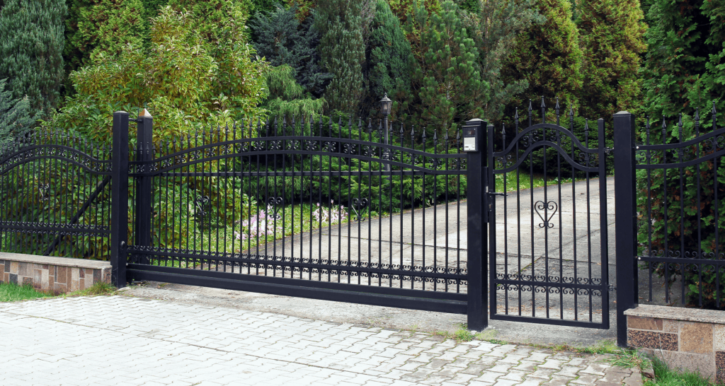Black wrought-iron driveway gate with side pedestrian gate