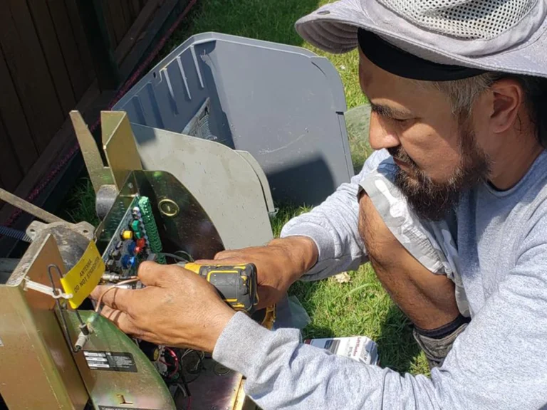 Everlast Gates & Fence technician repairing a broken automated gate in Farmers Branch