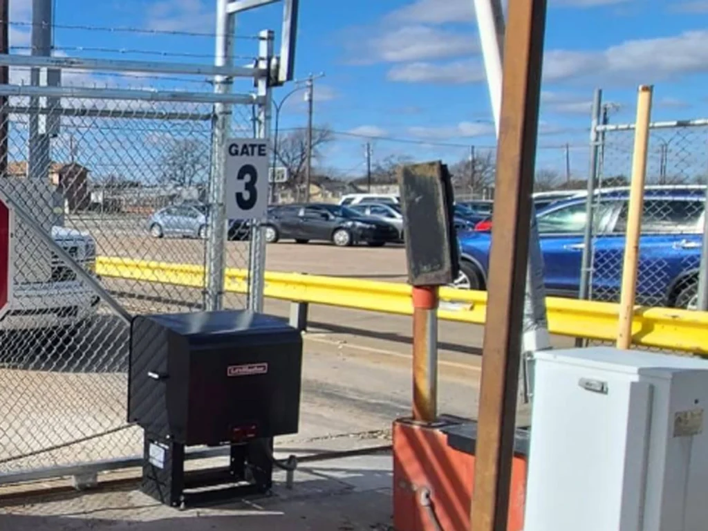 Technician installing a commercial automatic gate at a Plano business property