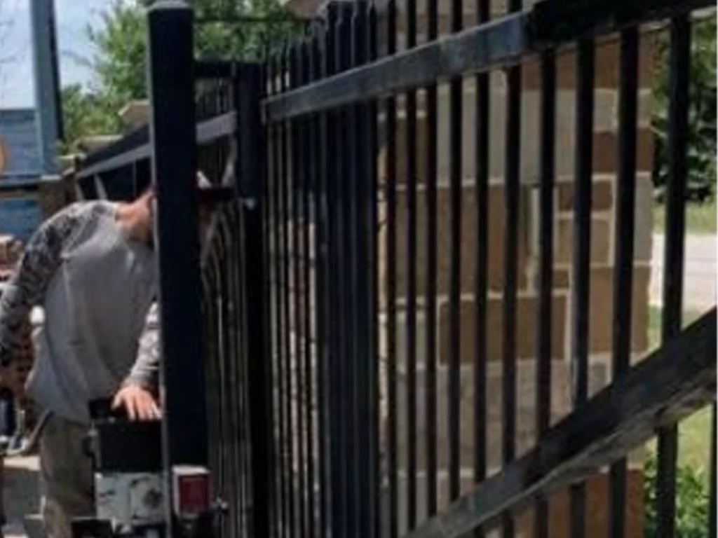 Technician installing a biometric and mobile access gate system for a Houston business