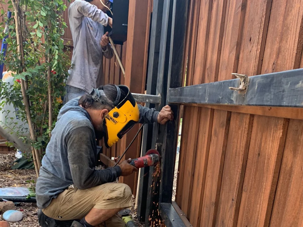Residential gate with a maintenance professional checking alignment and structure