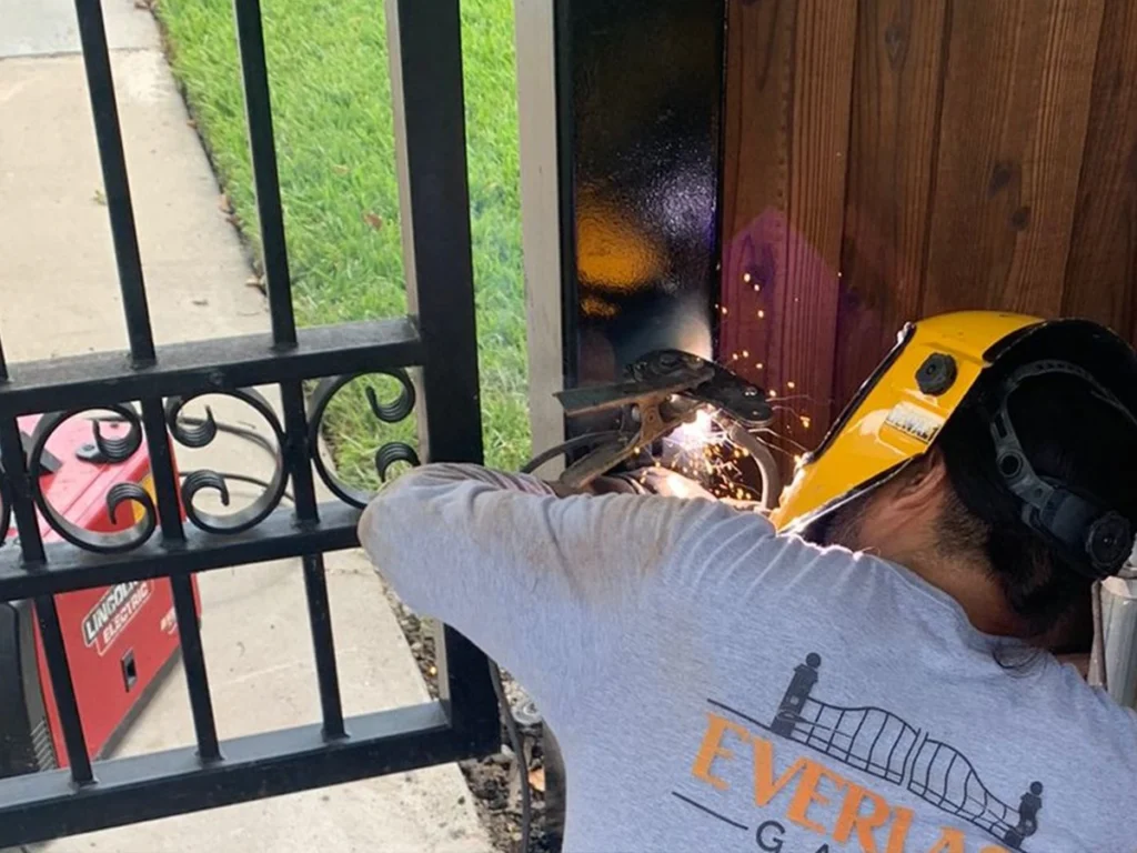 Homeowner inspecting a gate for repair in Farmers Branch, Texas