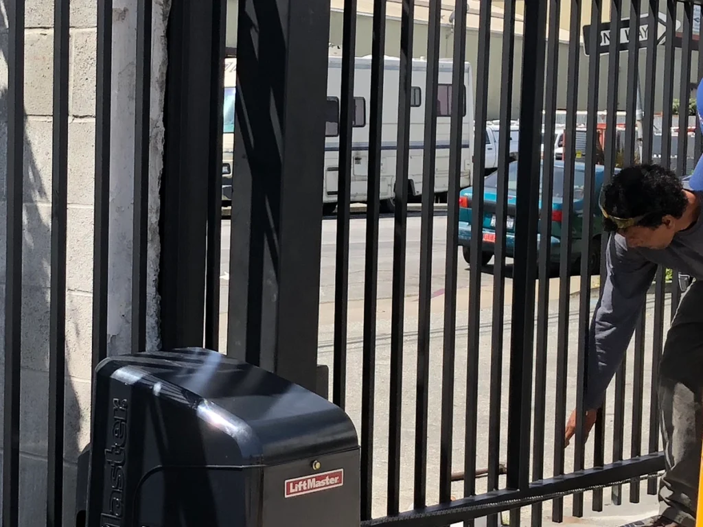 Technician repairing a commercial sliding gate in Plano, Texas