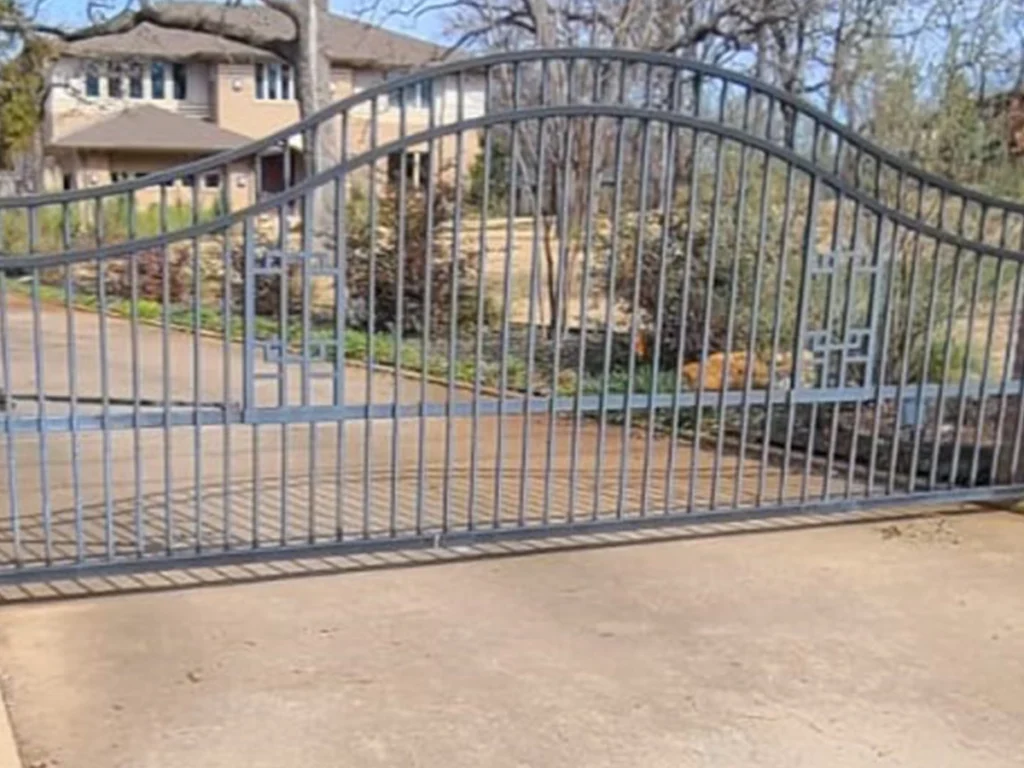 Technician installing a custom driveway gate in San Antonio, TX
