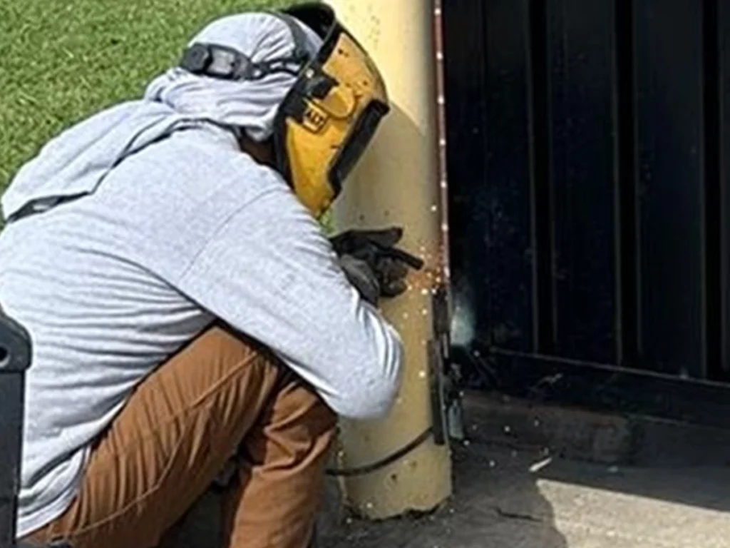 Technician performing gate and fence repair in Garland, TX