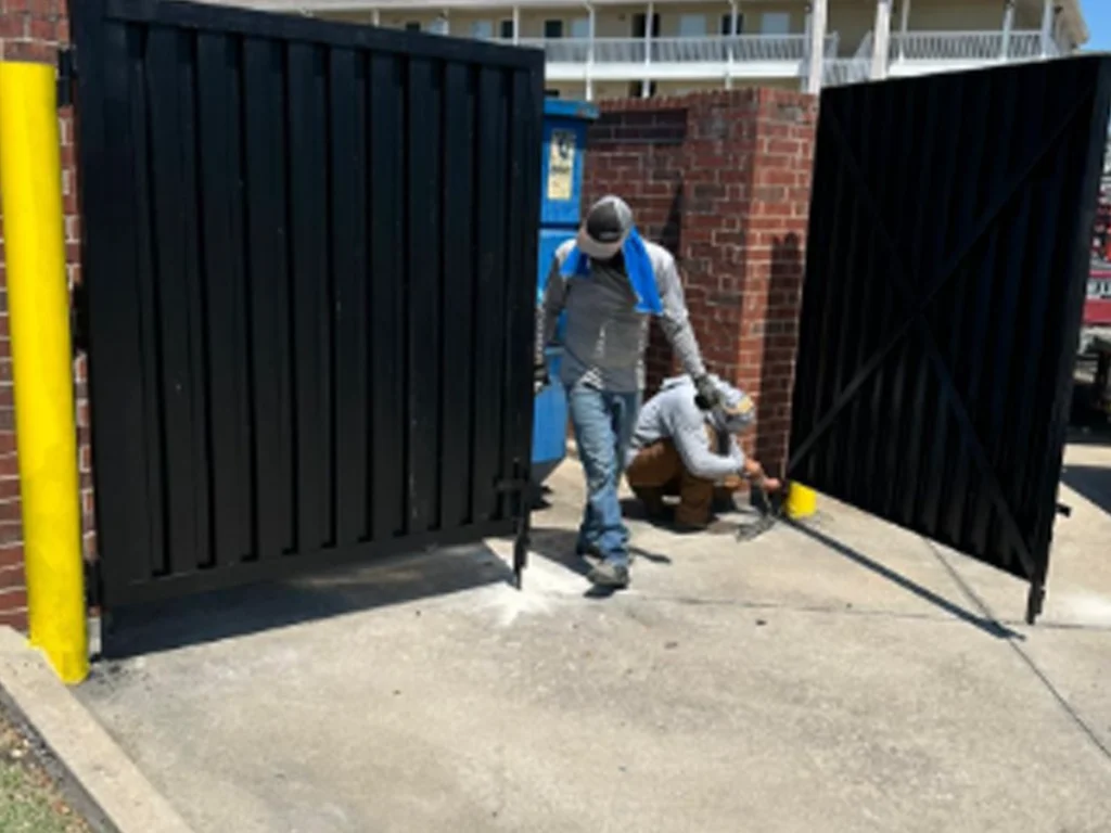 Technician performing Houston gate diagnostics on an automatic driveway gate