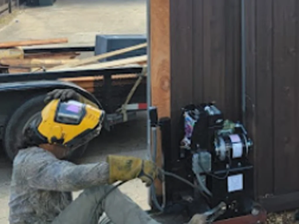 Technician performing electric gate repair on a Southlake property