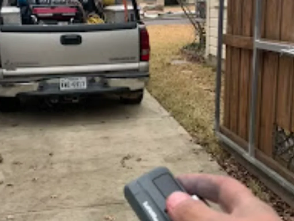 Technician installing a biometric and mobile access gate system for a Houston business