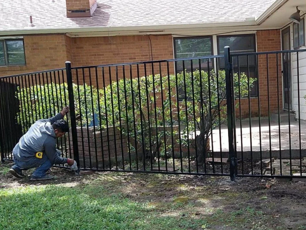 Beautiful, well-maintained iron fence surrounding a Carrollton home in bright sunlight