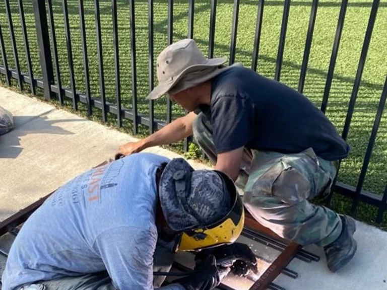 Technician repairing a fence in a Southlake backyard
