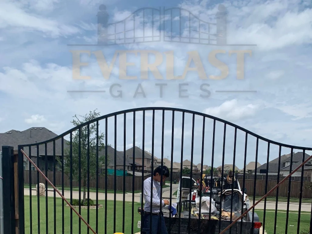 Professional installer fitting a driveway gate in Garland TX using top materials from Everlast Gates & Fence