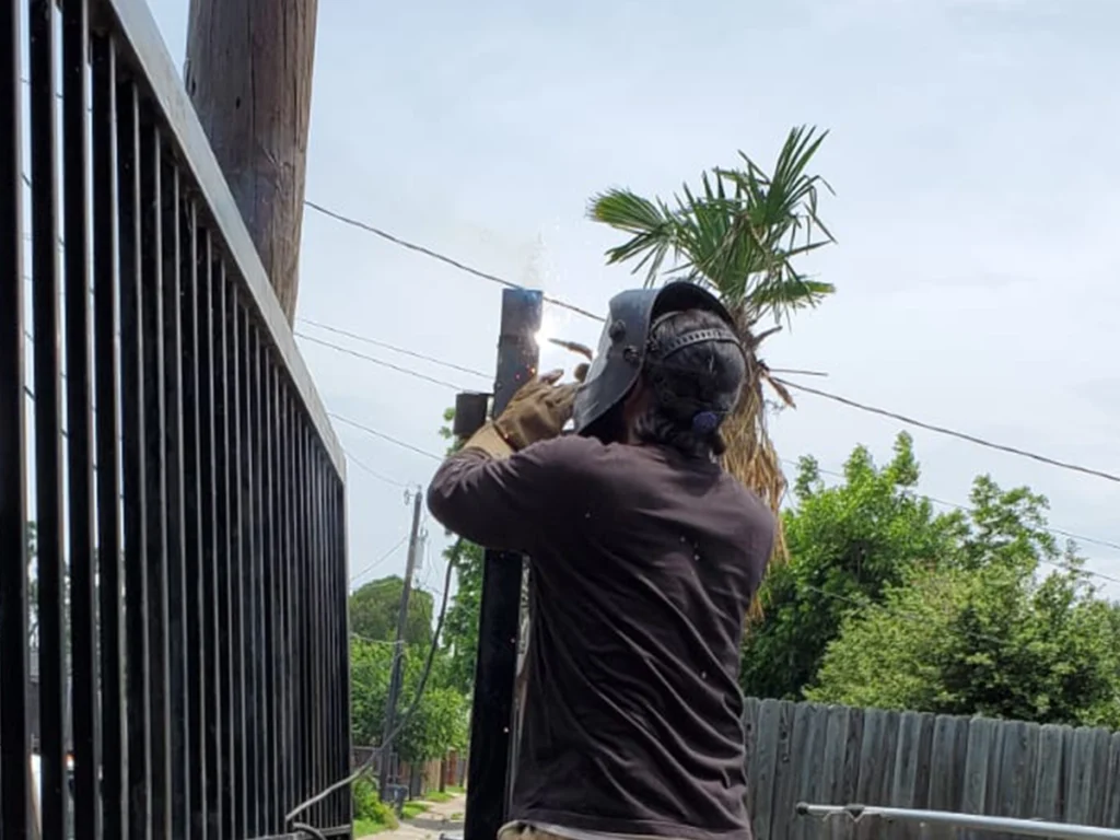 Technician expertly welding a broken gate at Everlast Gates & Fence in Plano, TX