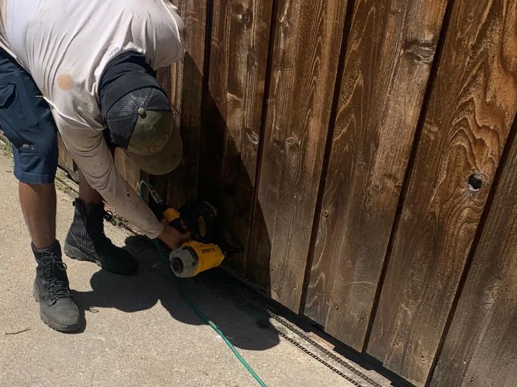 Technician repairing a sagging wooden gate in Houston